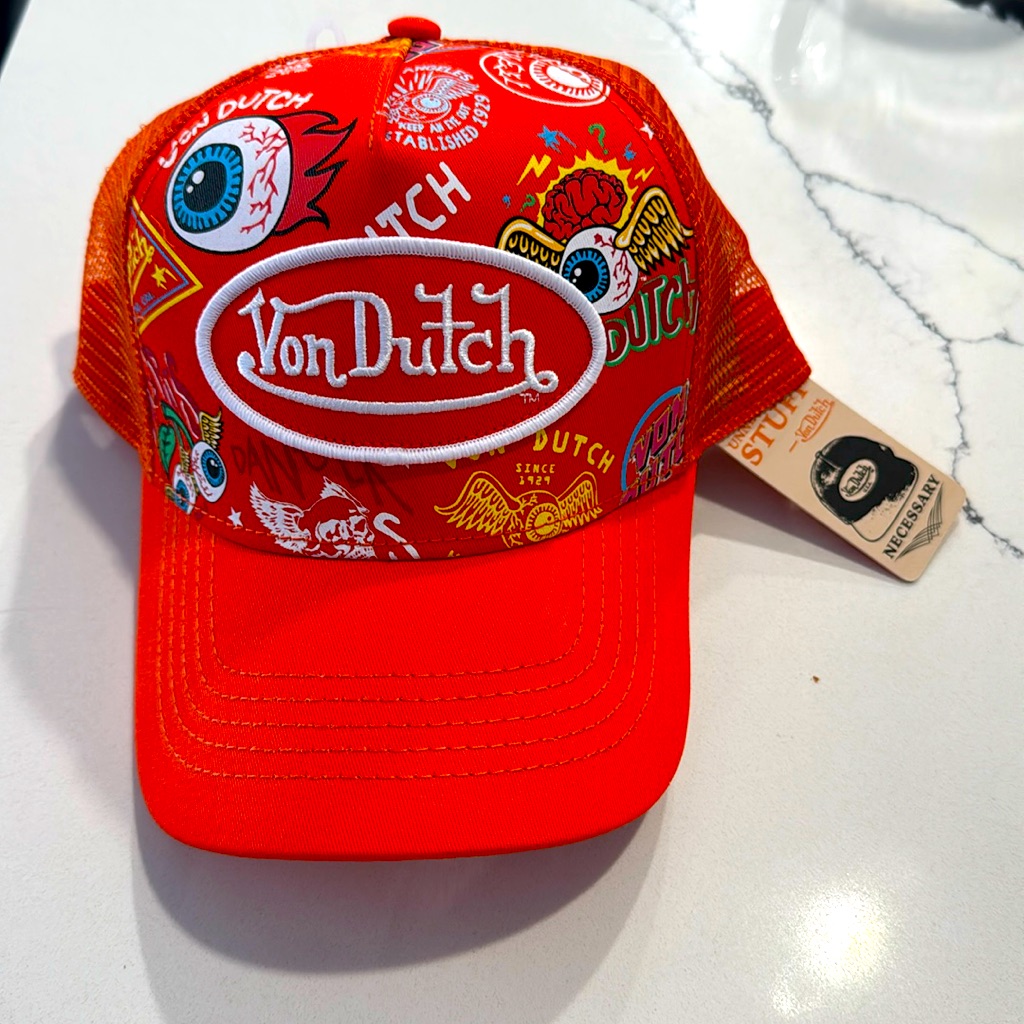Red Von Dutch trucker hat with the oval script logo and an all-over eyeball print, tag still attached